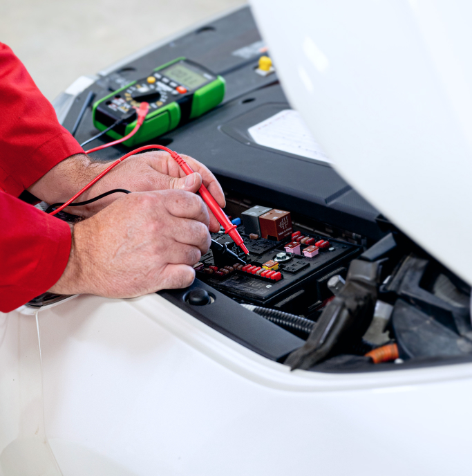 A car techinician using a Maktig multimeter to verify fuse box in the vehicle