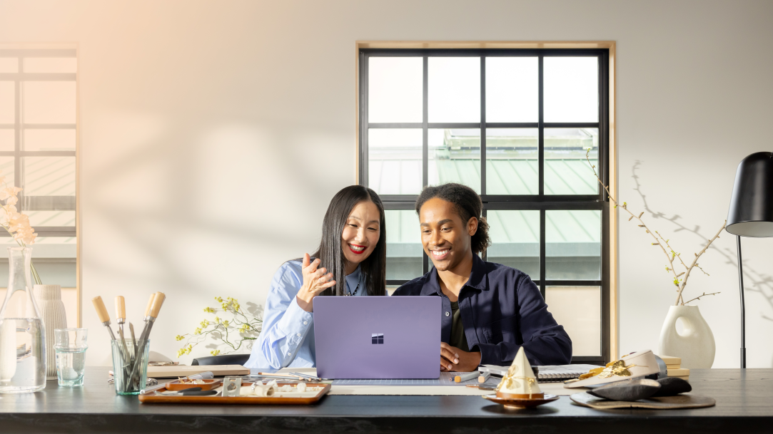 Two people using AI voice chat in Copilot on Windows while sitting at a table