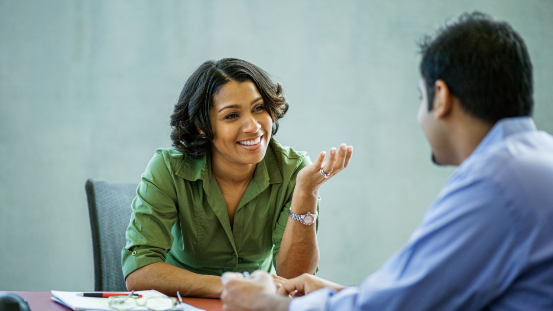 An interviewer engaging with an applicant during an interview about the skillsets they bring to the table