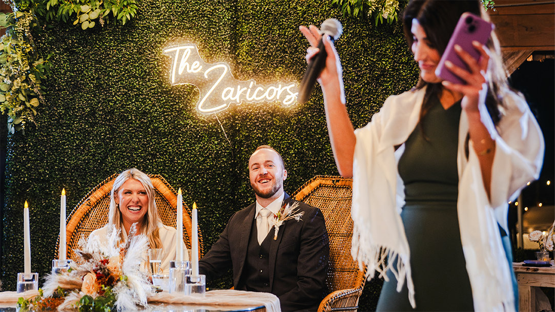 Image of a woman speaking in front of a wedding party