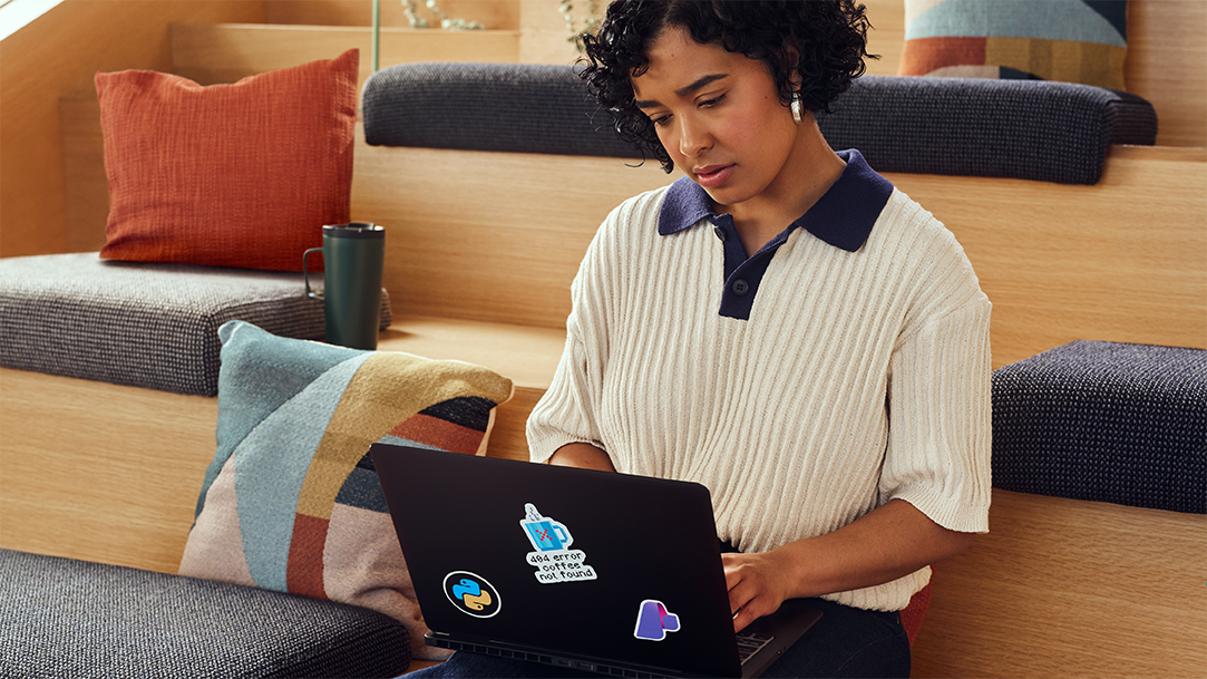 A person typing AI prompts on a laptop