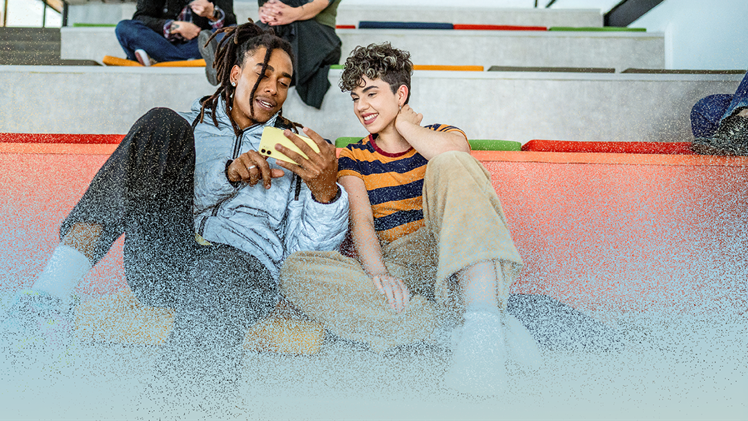 Young students friends talking and using mobile phone at auditorium