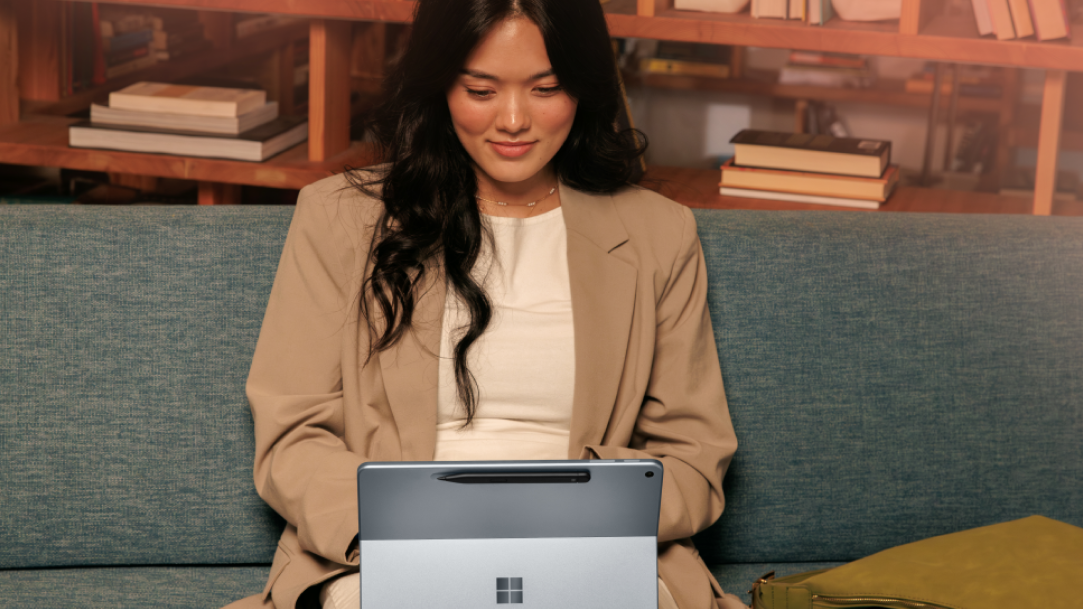 A woman typing on a Surface Pro, while out and about