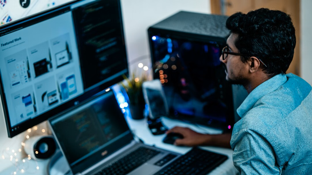 Man in a blue dress shirt using a computer at a desk