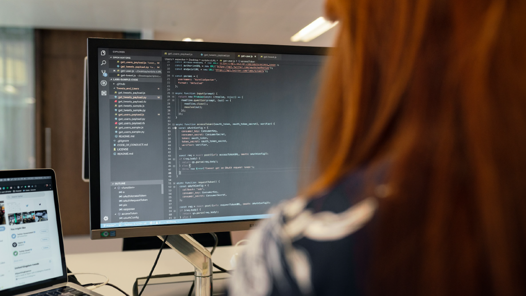 Woman sitting in front of a computer creating code