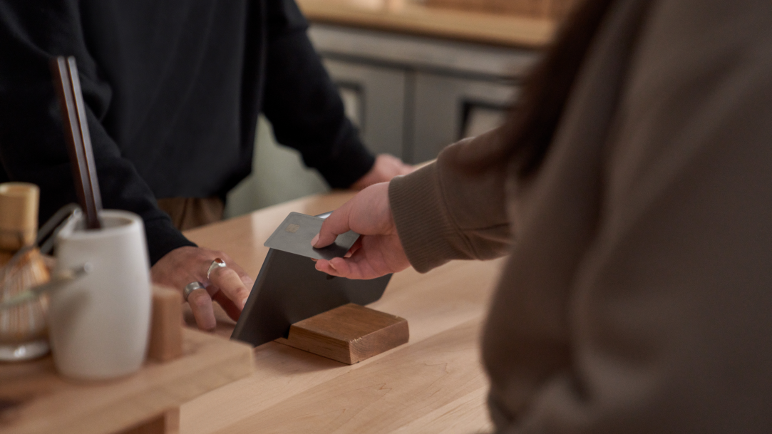 A person swiping a credit card at a kiosk