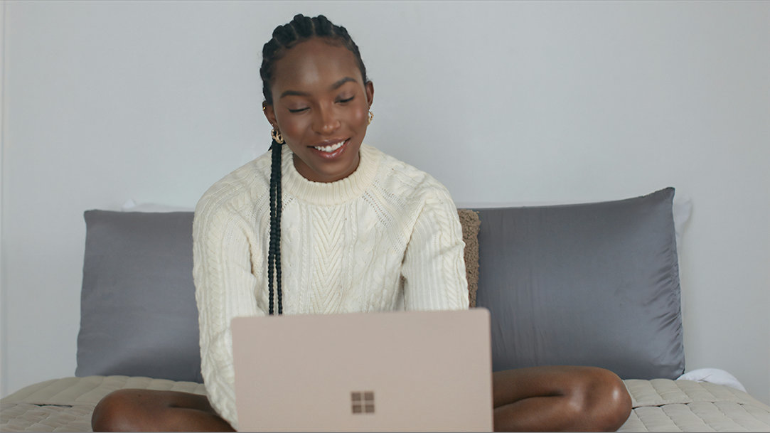A college student sitting on her dorm bed using the Microsoft AI writing assistant Copilot Pages to organize her lecture notes and prepare for a test