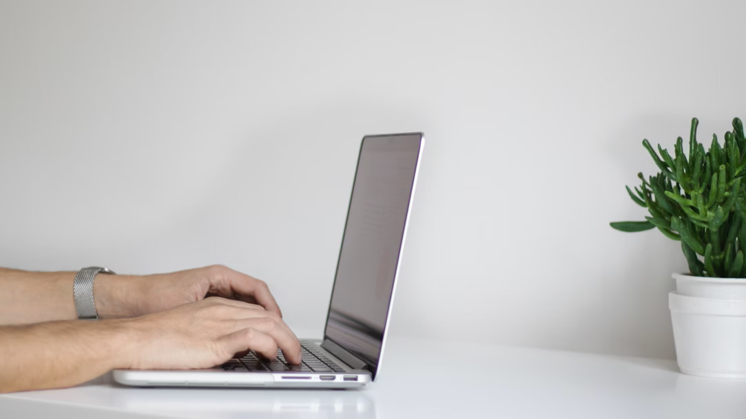 Hands typing on a Windows laptop