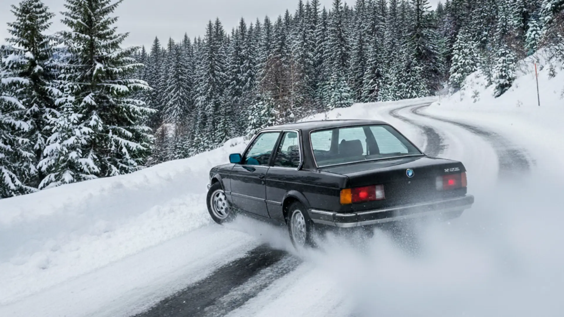 A rear-wheel drive BMW slips on a winding road
