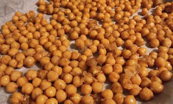 Uncooked chickpeas seasoned in a pan.