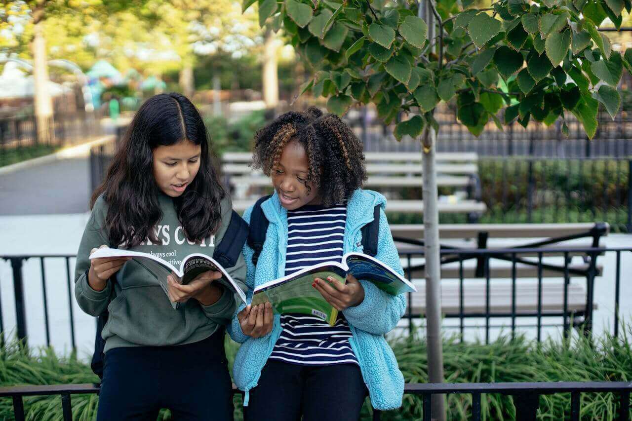 two-girls-comparing-notes-at-school