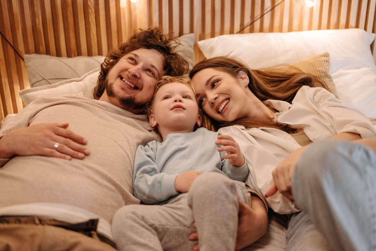 parents-and-toddler-relaxing-on-a-bed