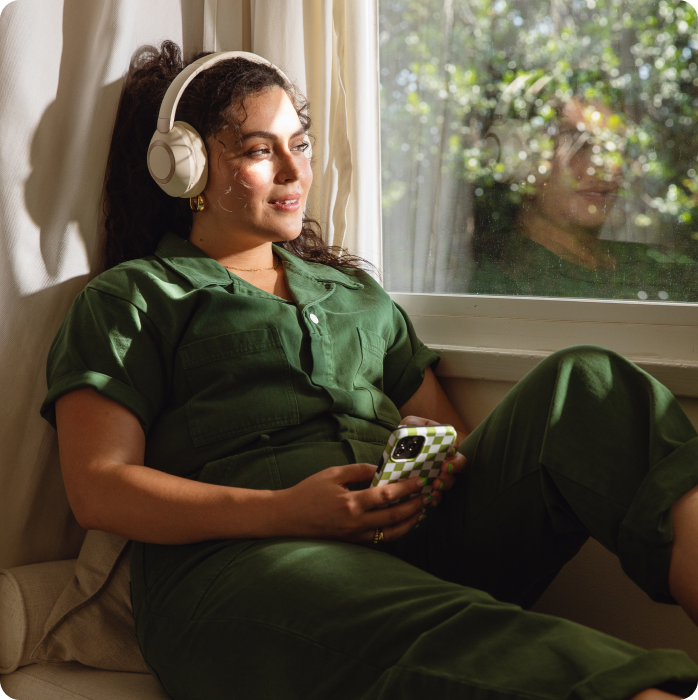 Woman sitting in window with headphones on