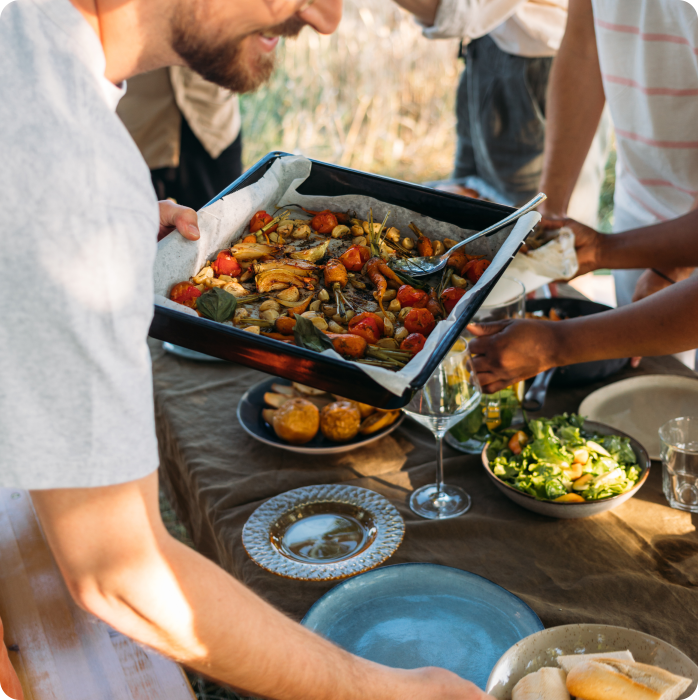 person grabbing food from a potluck