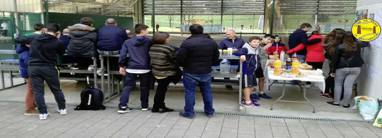 Participantes se reúnen alrededor de una mesa en la pista cubierta.