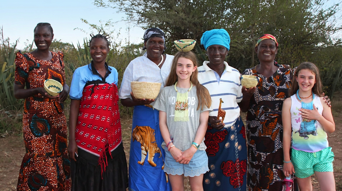 Two young travelers with Maasai women holding woven baskets in the Eastern Serengeti