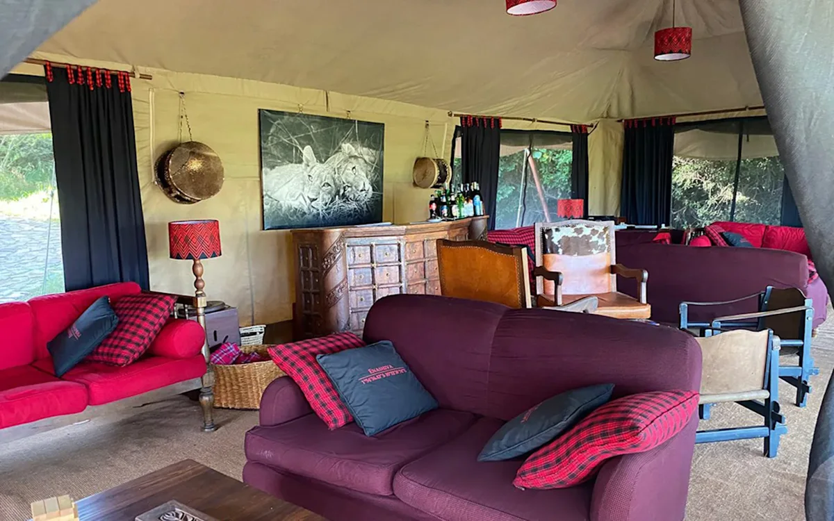 Lounge tent with sofas, rugs and wildlife art at Eastern Serengeti Nyumba