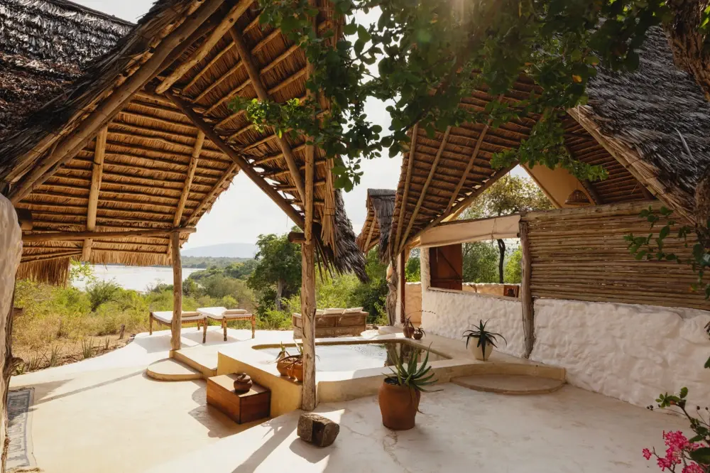 Open-sided thatched suite with a sunken tub and views over the bush at Sand Rivers, Nyerere National Park