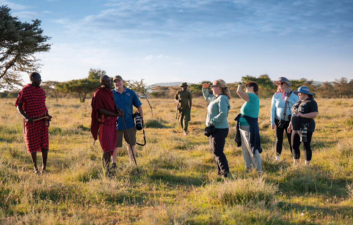 Guests on a walking safari with Maasai guides on open grassland