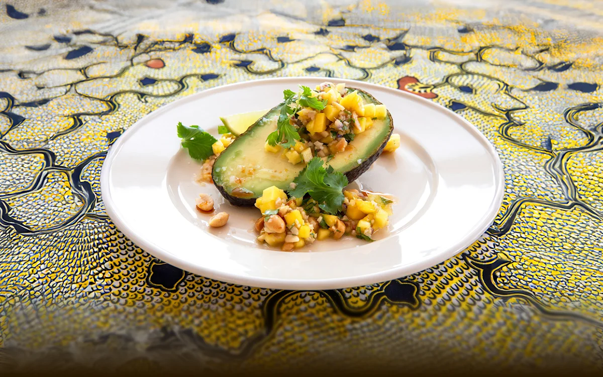 Avocado half filled with mango salad on a plate