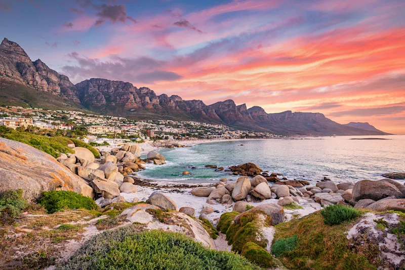 Camps Bay beach and the Twelve Apostles mountains in Cape Town at sunset