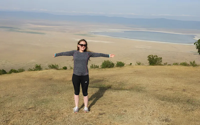 Carolyn with arms outstretched on the rim of Ngorongoro Crater