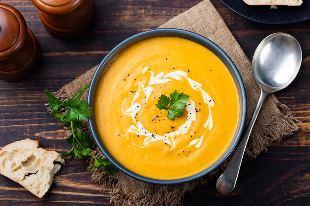 Bowl of carrot cilantro soup swirled with cream