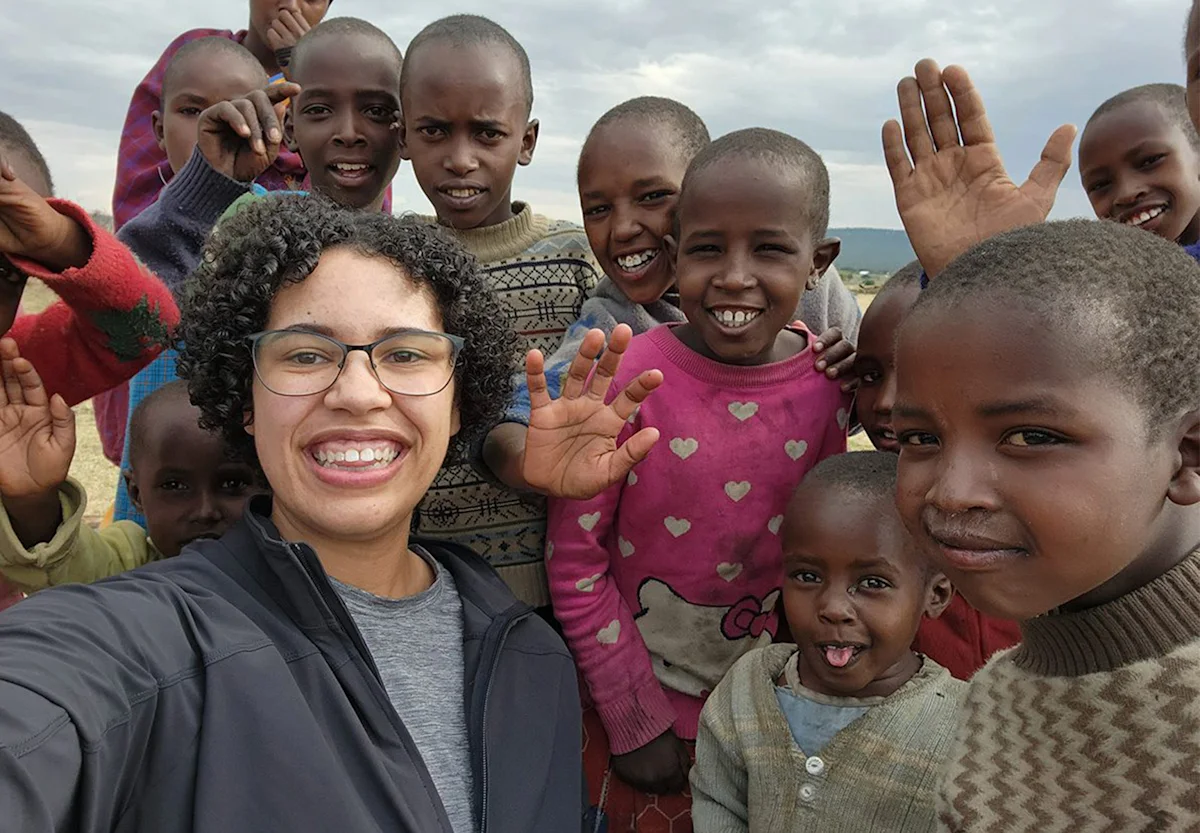 Thomson staffer Cat Yoder taking a selfie with smiling Maasai children