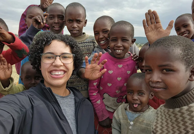 Thomson staffer Cat Yoder taking a selfie with smiling Maasai children