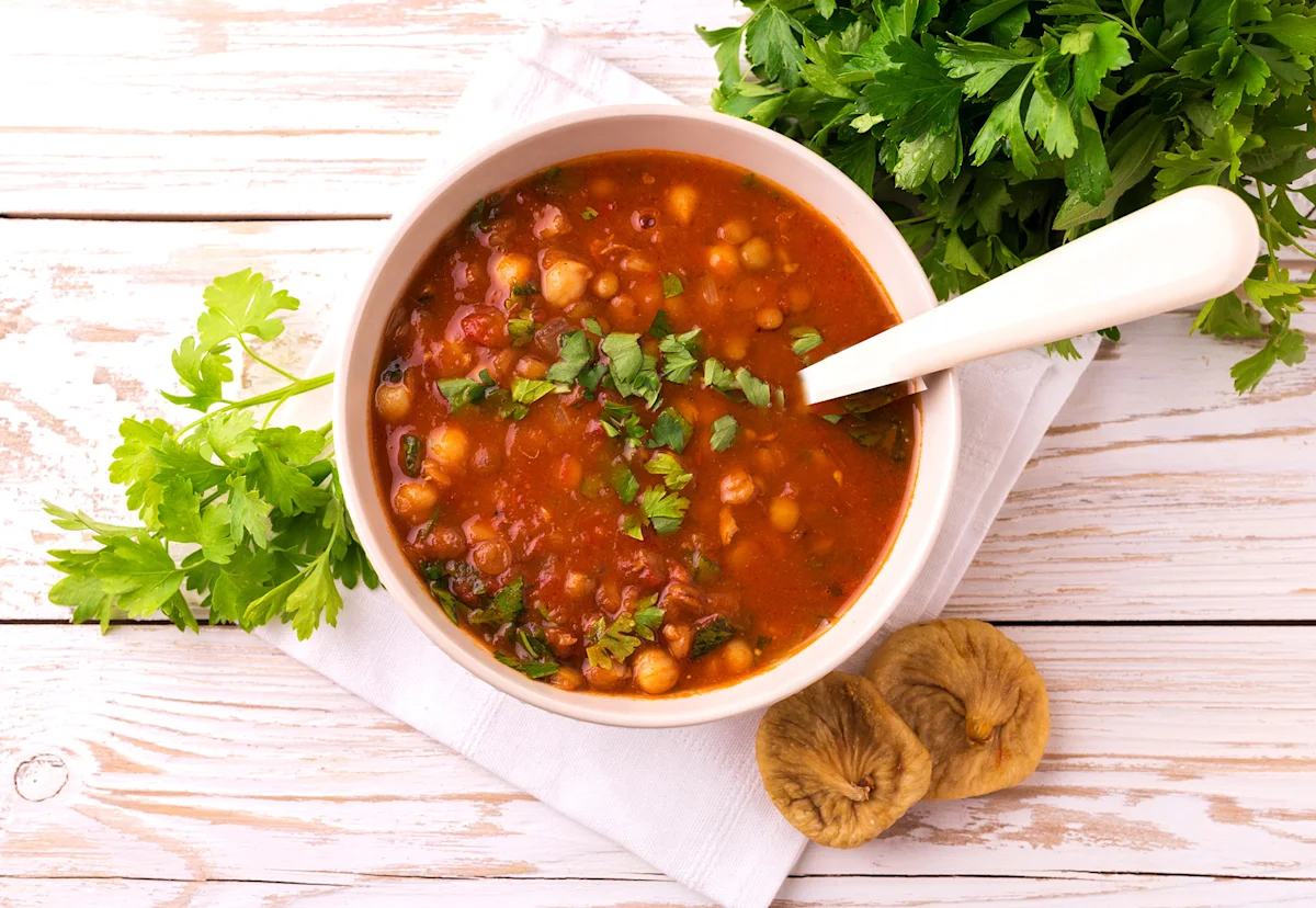 Bowl of chickpea and tomato soup with fresh parsley
