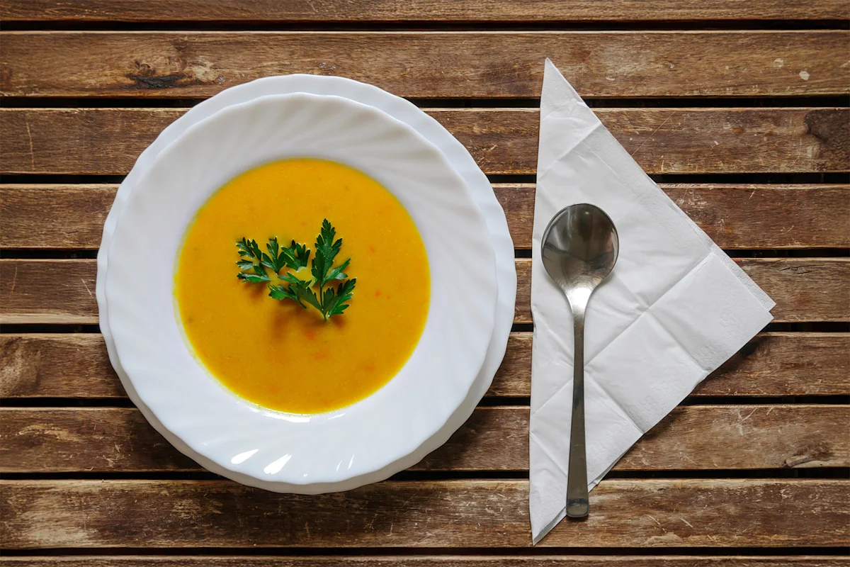Bowl of coconut pumpkin soup garnished with parsley