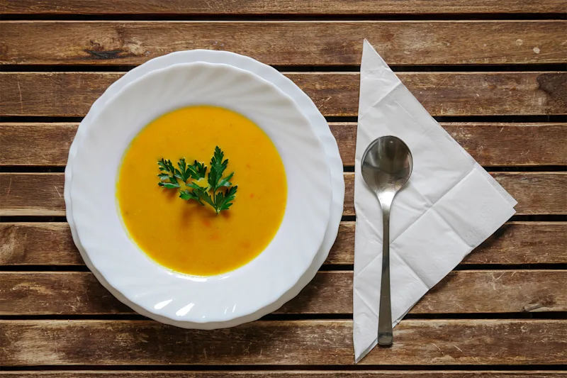 Bowl of coconut pumpkin soup garnished with parsley