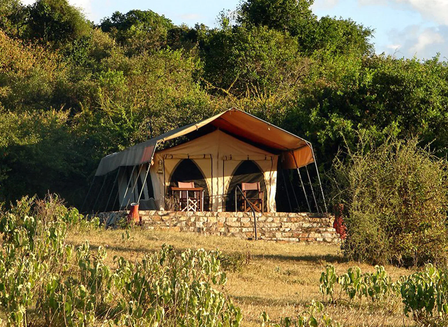 Canvas guest tent on a stone base surrounded by bush at Eastern Serengeti Nyumba