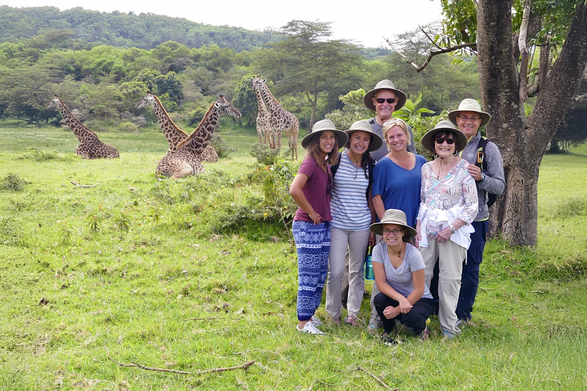 Family posing near giraffes on a Thomson family safari in Arusha National Park