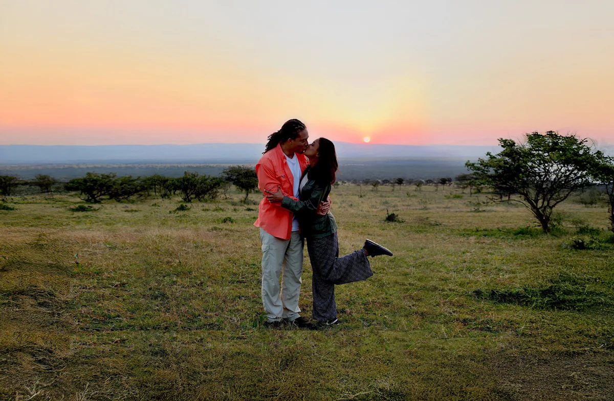 Couple kissing on the savanna at sunset