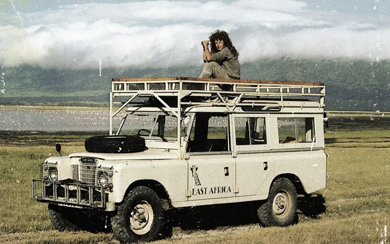 Judi Wineland on the roof of a vintage Land Rover at Lake Natron in the 1980s