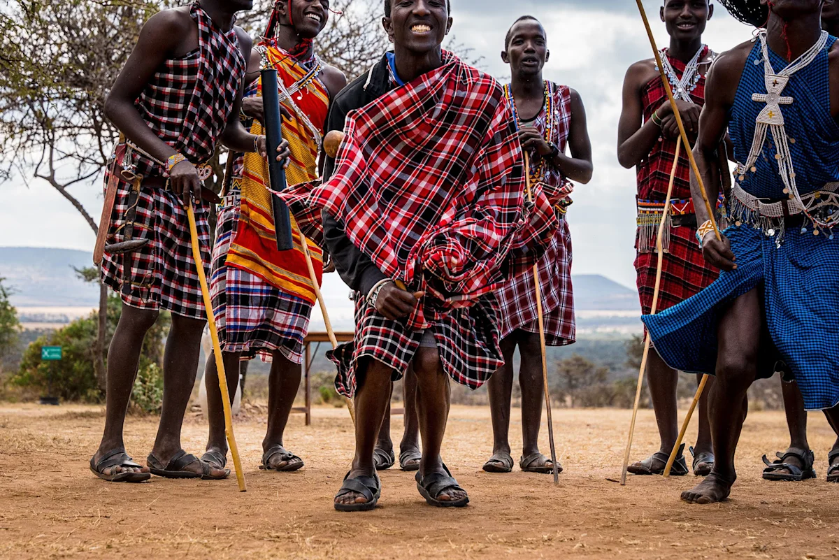 Maasai men in traditional shukas holding walking sticks