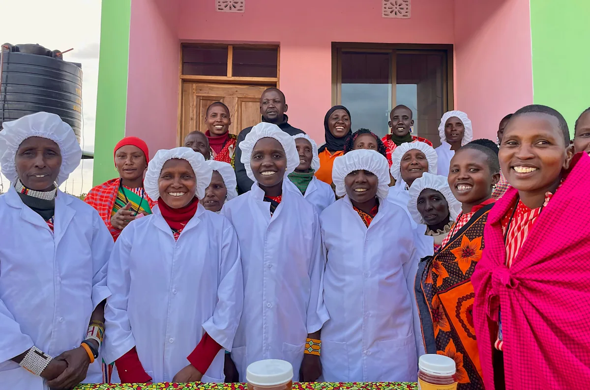 Maasai women of a FOTZC beekeeping group in white protective coats and hairnets