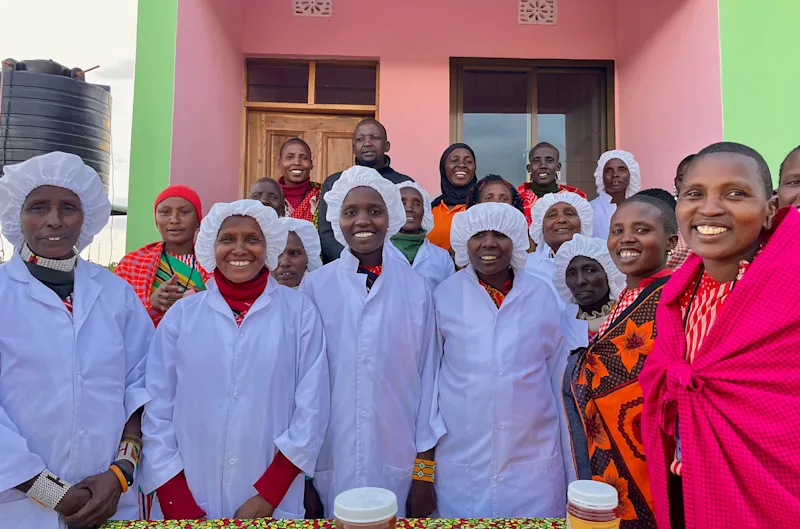Maasai women of a FOTZC beekeeping group in white protective coats and hairnets