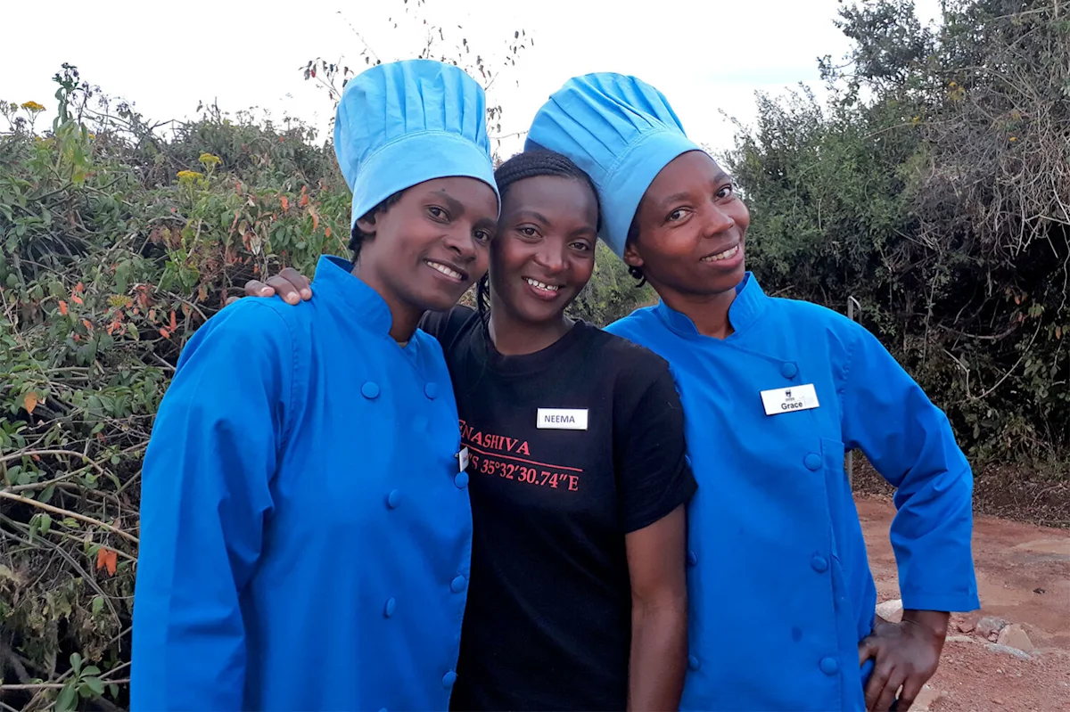 Three women staffers of the Thomson Nyumba camps, two in blue chef's jackets