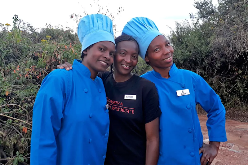 Three women staffers of the Thomson Nyumba camps, two in blue chef's jackets