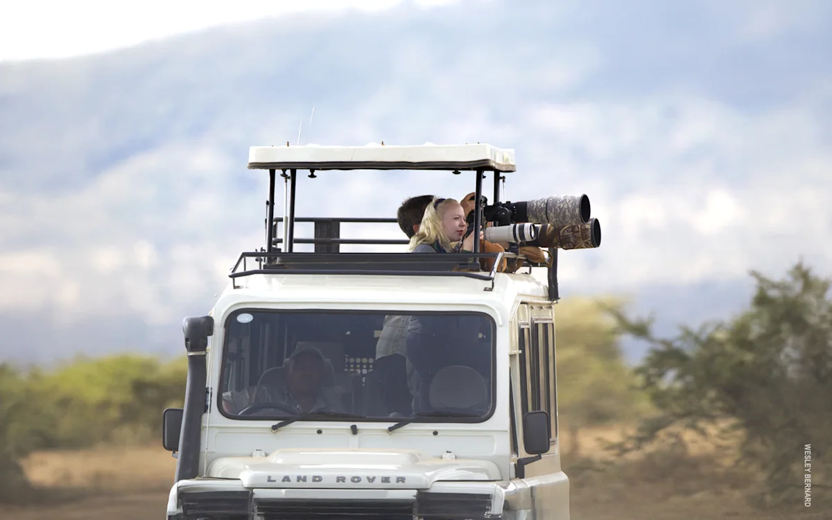 Photographer with a long lens in the roof hatch of a Thomson Land Rover