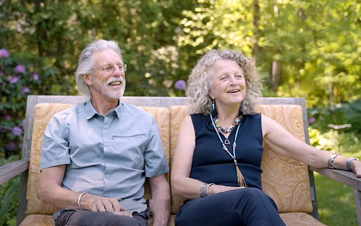 Judi Wineland and Rick Thomson smiling on a garden bench