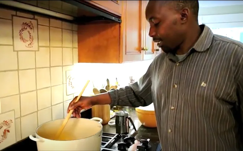 Thomson camp chef Herriel stirring a pot of soup on a stove