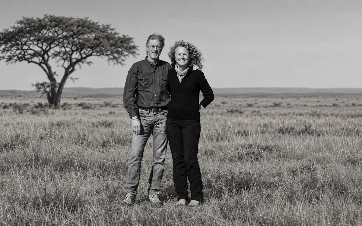 Black-and-white portrait of Rick Thomson and Judi Wineland standing on the savanna