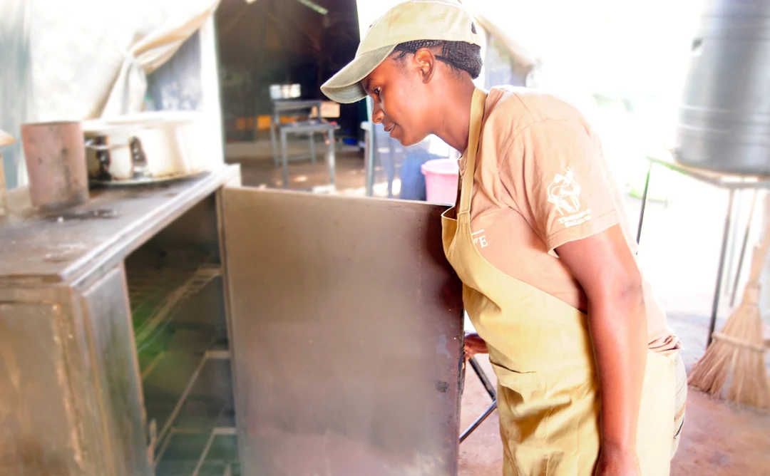 Camp chef Rebeka Maronde checking an oven in the safari camp kitchen