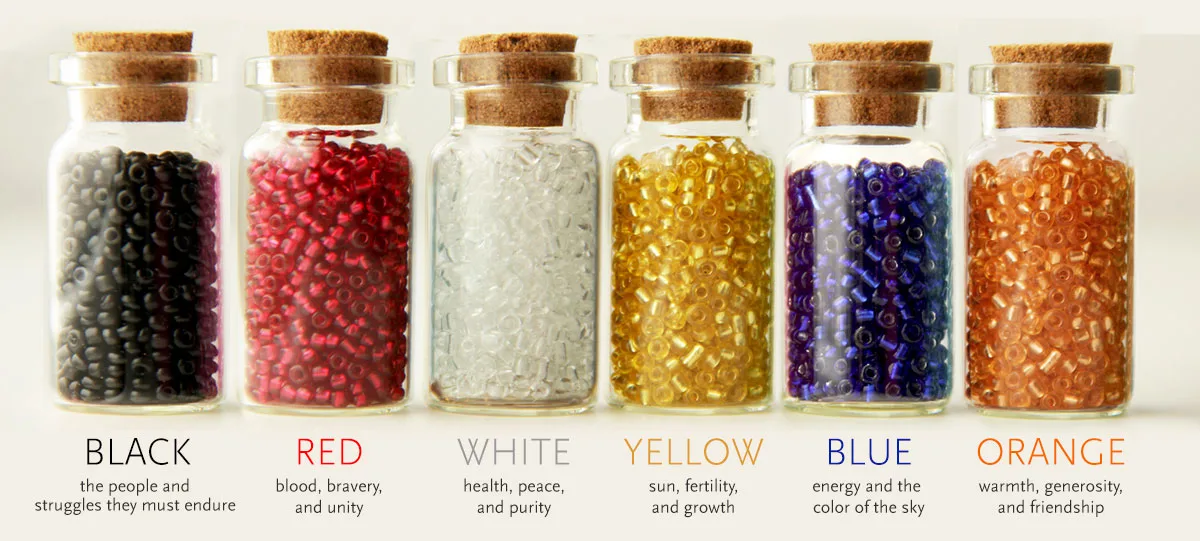 Jars of colored beads labeled with their Maasai meanings: black, red, white, yellow, blue, orange