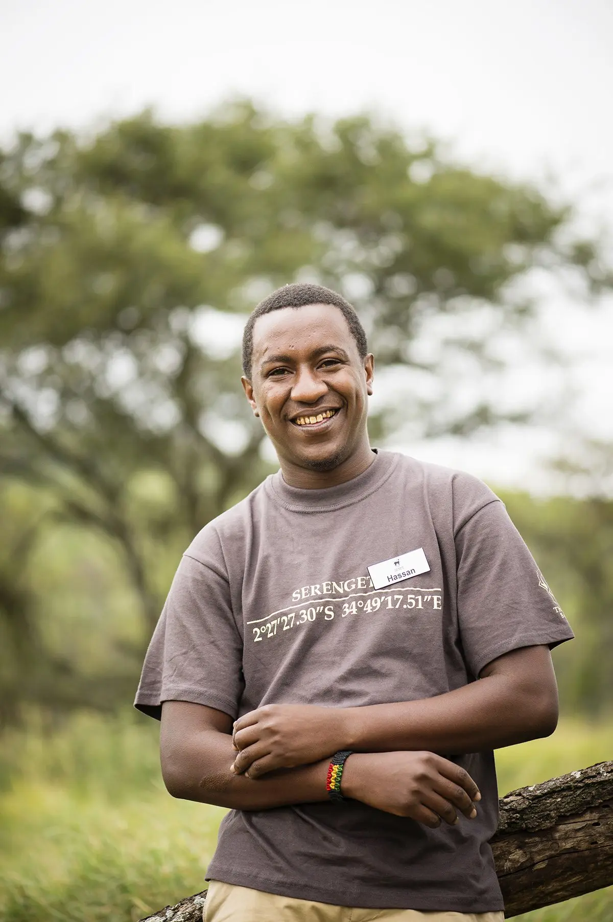 Smiling Thomson camp staff member in a branded t-shirt standing outdoors