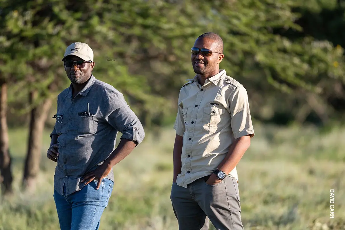 Two Thomson guides standing in the bush wearing sunglasses