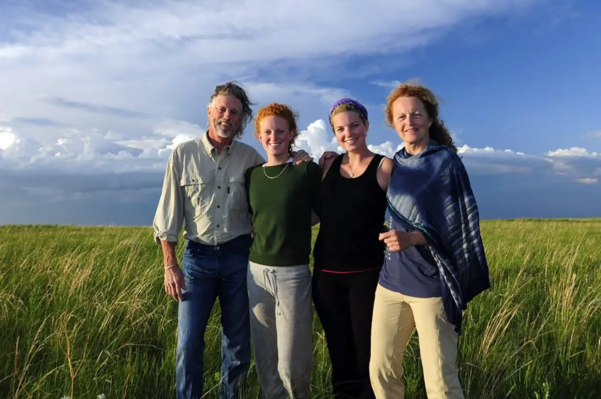 Rick Thomson and Judi Wineland posing with two young women on green grassland